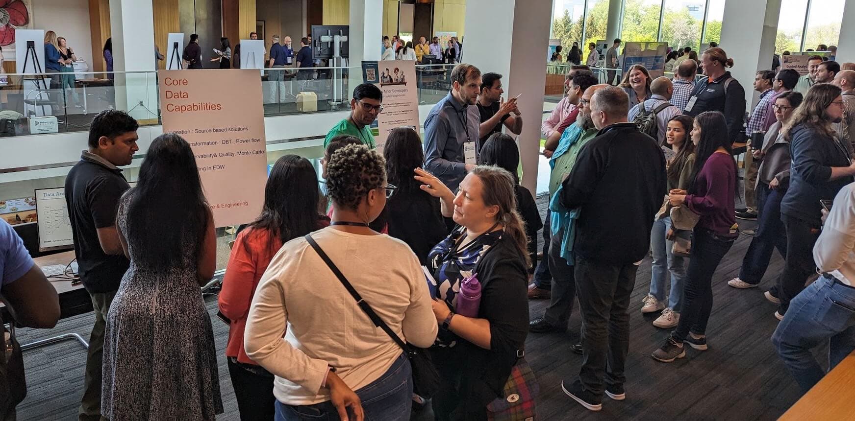 People exploring the booths at a corporate tech showcase.
